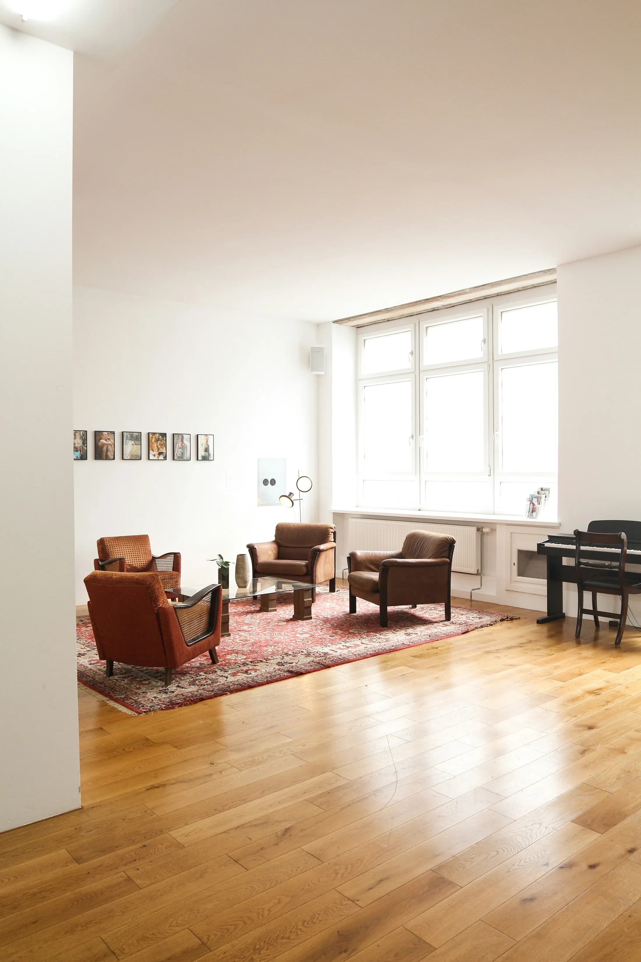 Berliner Innenraum mit Parkett, Sitzgruppe und Klavier